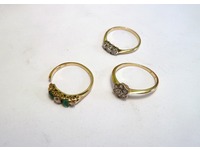 Three rings yellow gold rings set with a selection of sized diamonds and emeralds