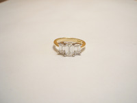 Three stone ring set with emerald cut diamonds in a demi rubover setting.