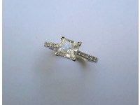 Centre Princess cut diamond with round diamonds micro set on each shoulder.